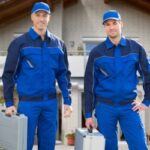 Two pest control technicians in uniform hold cases filled with pest control equipment