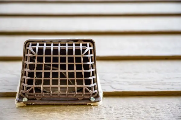 Metal vent cover on the side of a house